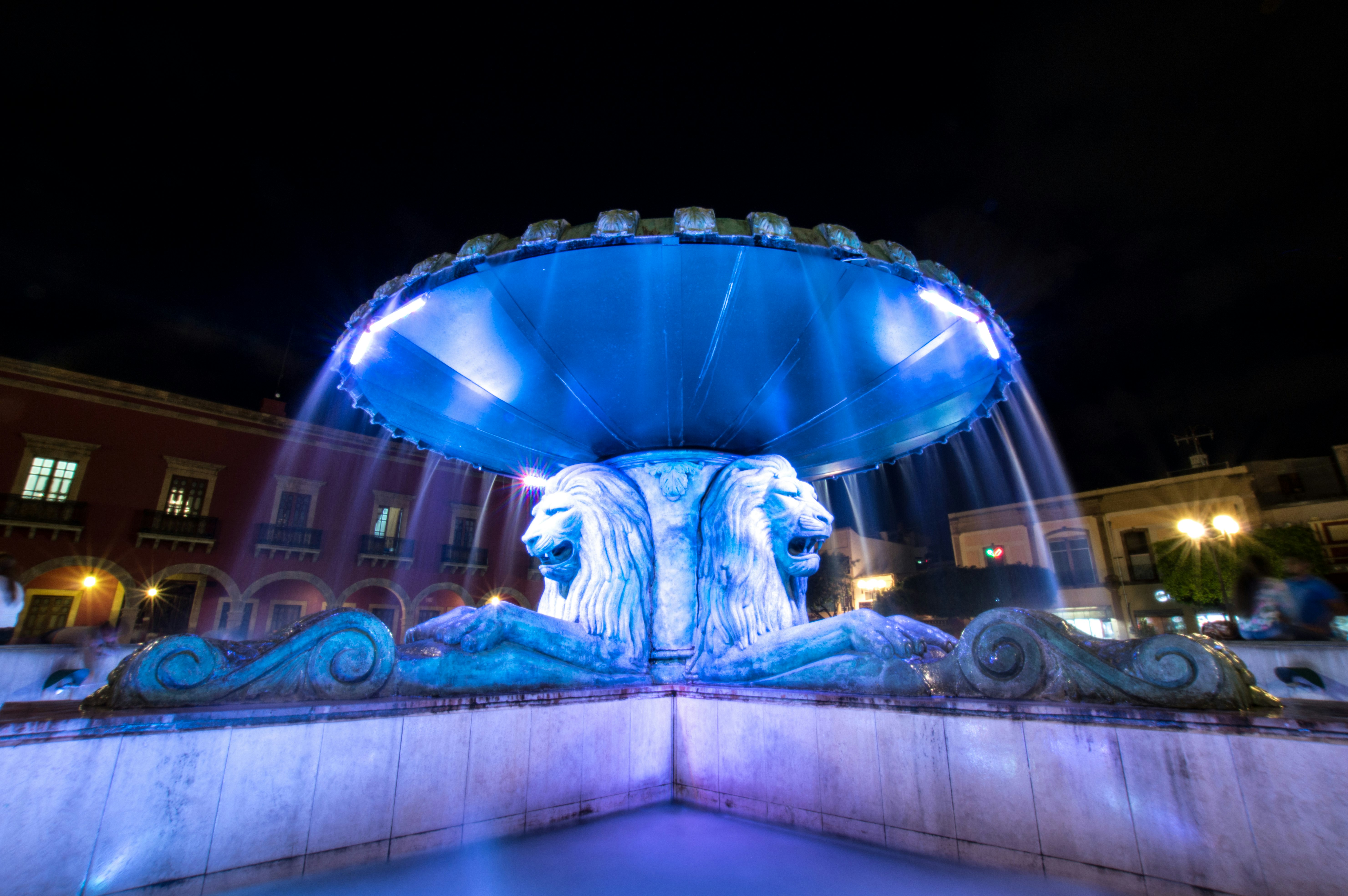 lion fountain with blue light in middle of fountain